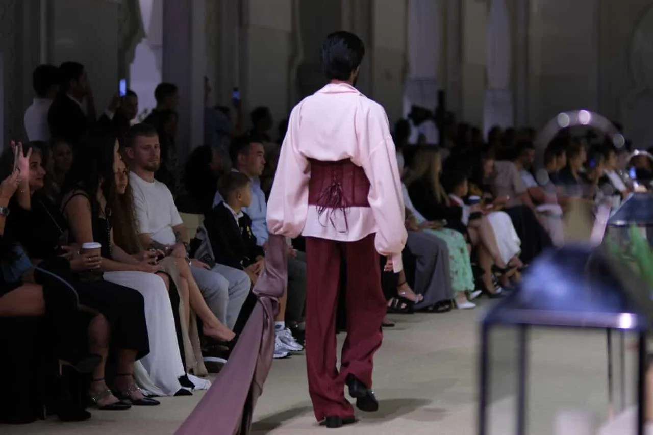 A model presenting a garment to an audience at a fashion show.