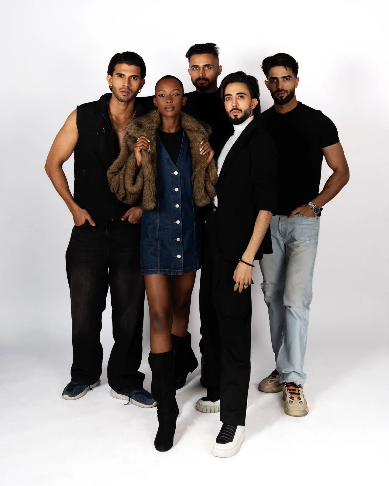 Five models posing together in a professional studio photoshoot.