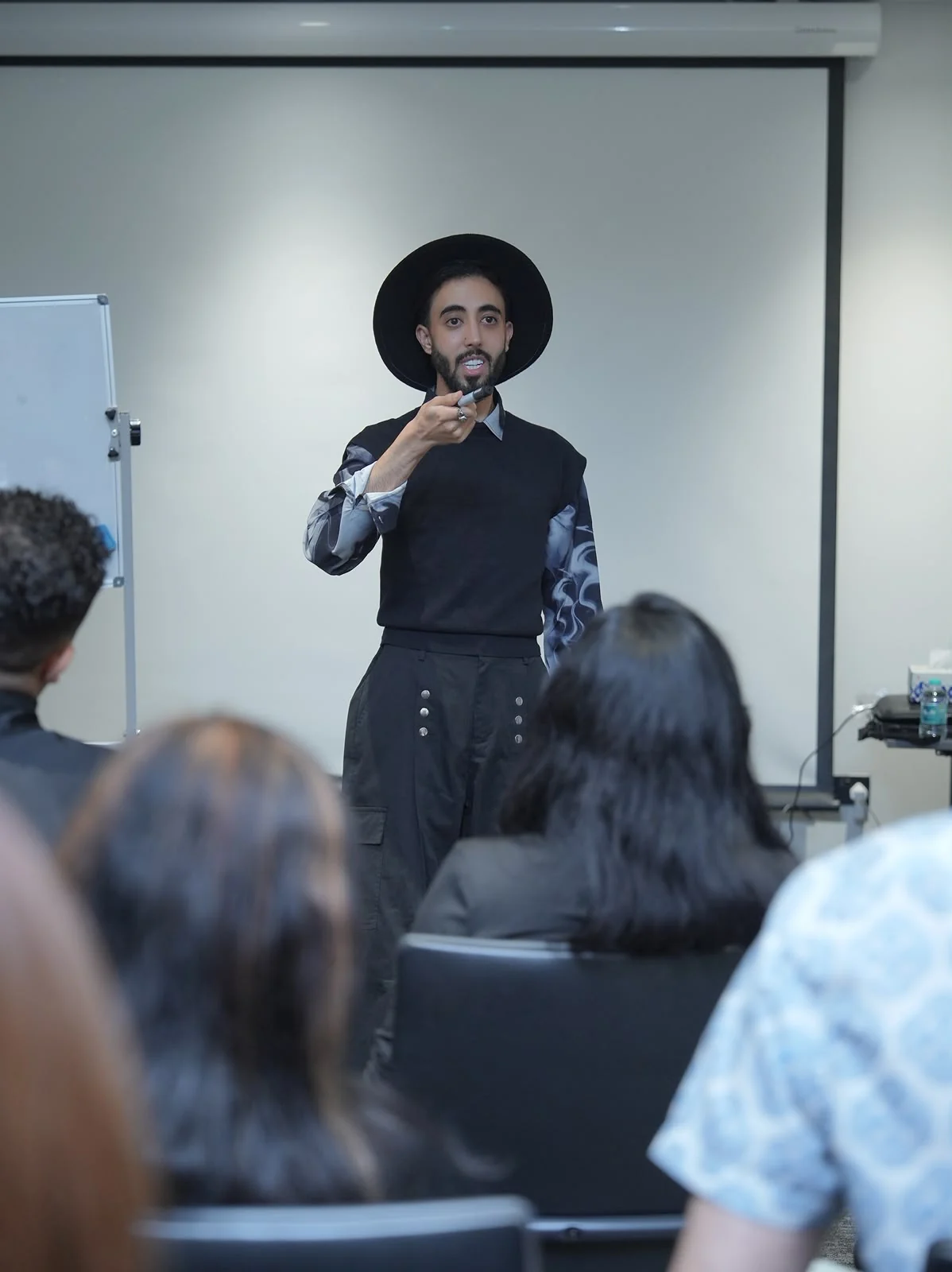 A model speaking to academy students during a training session.